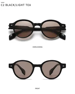 Lunettes de soleil rondes noires classiques en détail, monture élégante, verres clairs.
