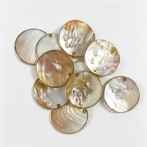 Close-up detail of natural mother of pearl round shell pendant with gold plated rim for DIY jewelry.