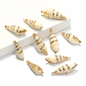 Gros plan détail de pendentifs coquillage blanc galvanisé avec des bords dorés pour bijoux DIY.