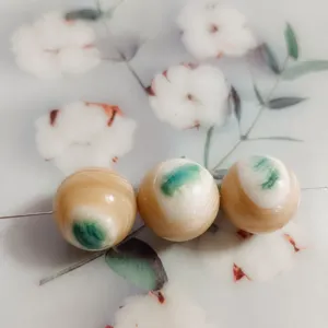 Close-up detail of large green stripe mother-of-pearl round beads, ideal for DIY jewelry crafting.