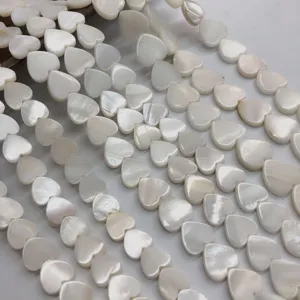 White mother-of-pearl heart shaped shell beads close up detail view for diy jewelry making