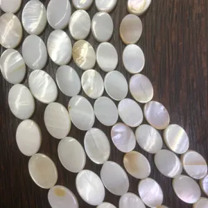 Close-up detail of natural white oval shell loose beads, perfect for DIY jewelry making.