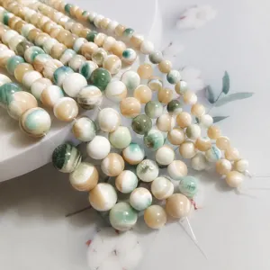 Green snail mother-of-pearl shell round beads detail closeup for DIY jewelry making.