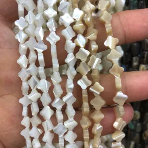 Detailed view of carved clover shell beads for DIY handmade jewelry bracelets necklaces