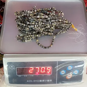 Detail view of black mother of pearl shell spacer beads on scale for DIY jewelry making.