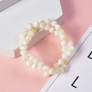 White mother-of-pearl shell bead strand detail showing natural luster and smooth round surface.