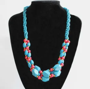Detailed view of the multi-strand turquoise and pink beaded necklace with gold spacers.