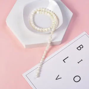 Close-up detail view of white mother of pearl round beads strand, perfect for DIY jewelry making.