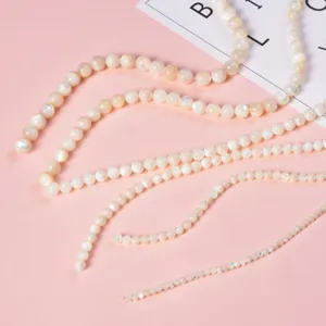 Close-up detail of white mother-of-pearl shell bead strands for DIY jewelry making.