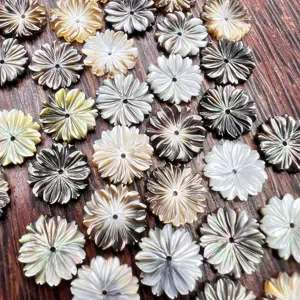 Detail view of 12mm carved mother of pearl flower beads for DIY jewelry making and crafts.