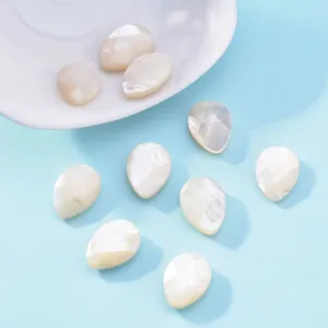 Detailed view of faceted white mother of pearl teardrop shell beads for DIY jewelry making.