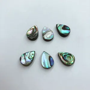 Detailansicht von tropfenförmigen Abalonemuschel-Cabochons, lebendige schimmernde DIY-Perlen.