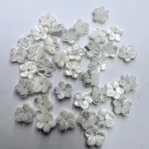 Detailed close-up of carved white shell flower loose beads, perfect for DIY jewelry making.