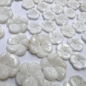 Close up of white carved shell flower beads, natural mother-of-pearl detail for DIY jewelry.