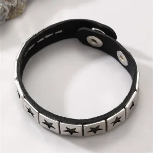 Detailaufnahme des schwarzen Lederarmbands mit silbernen quadratischen Stern-Nieten.