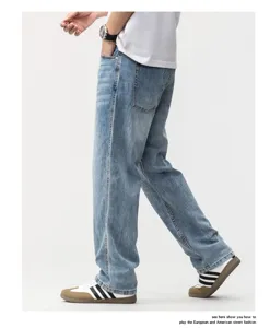 Side view of a model wearing men's loose straight-leg denim jeans in light blue vintage wash