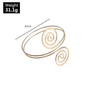 Gedetailleerd overzicht van de gouden spiraalarmband van metaal, met geometrisch ontwerp.