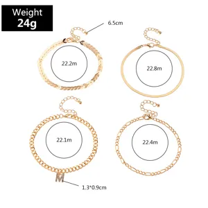 Set of four gold-toned anklets featuring various chain styles and a sparkling letter pendant design.