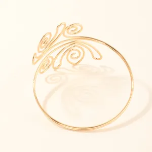 Gouden metalen armband detailopname met een ingewikkeld geometrisch filigraan patroon.