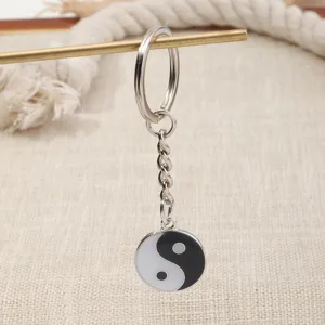 Yin-yang metal keychain pendant detail shot, minimalist style accessory for everyday use.
