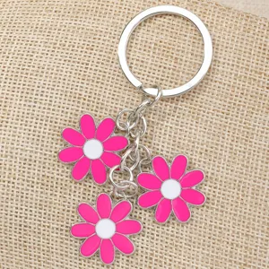 Pink and white daisy flower charm detail on keychain close up accessory shot for styling.