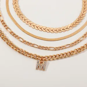 Detailed view of multi-layer gold-plated necklace set with a sparkling rhinestone letter pendant.