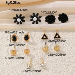 Set aus stilvollen Ohrsteckern in Schwarz und Gold mit Blumen und geometrischen Formen.