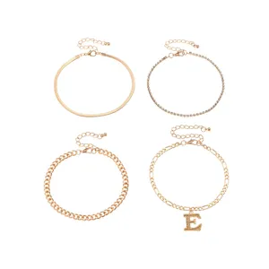 Set of 4 gold-plated anklets featuring snake chain, rhinestone chain, and letter E pendant.