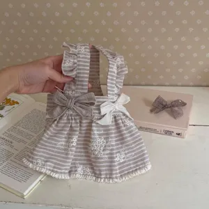 Vista detallada de vestido transpirable para mascotas con rayas y bonito bordado floral.