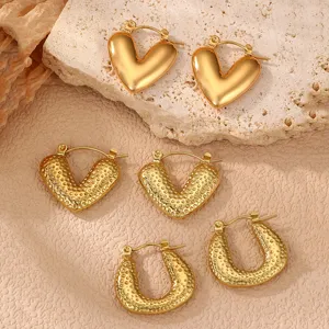Set aus goldenen Edelstahl Ohrringen mit glatten Herzen und strukturierten Hufeisen Formen Damen.
