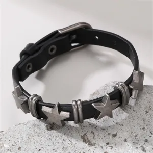 Nahaufnahme des schwarzen Lederarmbands mit Sternen und Metallanhängern, Punk-Schmuck.