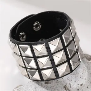 Detailaufnahme des schwarzen Lederarmbands im Punk-Stil mit silbernen Pyramiden-Nieten.
