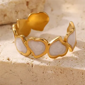 Detailaufnahme eines goldfarbenen offenen Rings mit ineinandergreifenden Herzmotiven.