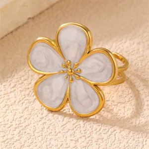 Eleganter Vintage-Edelstahlring in Goldoptik mit filigraner weißer Blumen-Einlage als Detail.