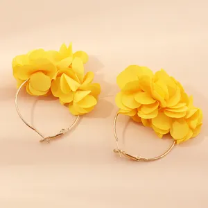 Nahaufnahme Detail gelber Stoffblumen Creolen mit feiner und zarter Blumenstruktur.
