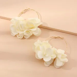 Schicke goldene Creolen mit eleganten weißen Stoffblumen für Damen und Modeaccessoires.