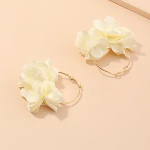 Nahaufnahme von weißen Stoffblumen-Creolen mit einer goldfarbenen Metall-Legierungsbasis.