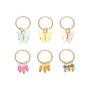 Goldene Haarringe mit bunten Schmetterlings- und Perlenhängern, ideal für Flechtfrisuren.
