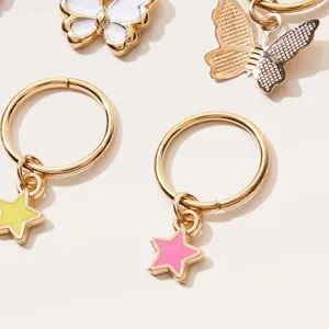Detaillierte Nahaufnahme von goldfarbenen Stern- und Schmetterlings-Haarperlen für DIY-Schmuck.