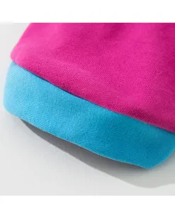 Close-up detail of cute pet hoodie knit fabric, pink and blue contrast color design.