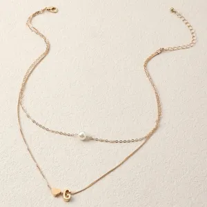 Doppellagige Goldkette mit Perlenanhänger und einem süßen Buchstaben G Herz Charm Detail.