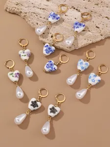 Detailed close-up view of vintage blue-and-white porcelain heart pearl drop earrings.