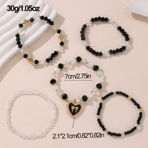 Schickes schwarz-weißes Perlenarmband-Set mit süßem Schleifen-Herz-Anhänger für Damen.