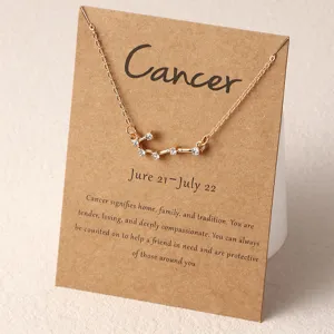 Goldfarbene Sternzeichen Krebs Strass Halskette auf einer braunen Karte fuer Damen Schmuck.