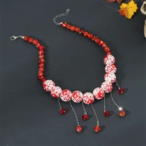 Close up view of the Halloween red and white beaded necklace with delicate tassel chains.