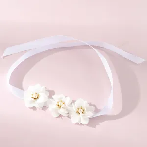 Gedetailleerd overzicht van witte lint polsbloem met parels voor bruidsmeisje huwelijk feest