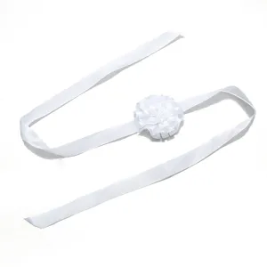 Close-up detail van de elegante witte stoffen bloem polsband, met een delicate textuur.