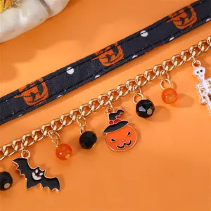 Vista di dettaglio del bracciale con ciondoli di Halloween con zucca e pipistrello.
