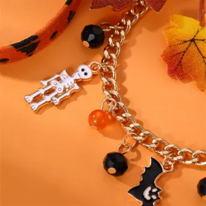 Primo piano dettagliato del braccialetto con ciondoli di Halloween, scheletro, catena dorata.