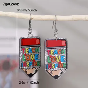 Gros plan détaillé de boucles d'oreilles crayon en résine avec texte et texture pailletée.